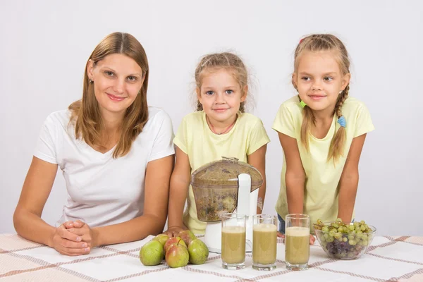 Mãe e duas filhas para cozinhar para três copos de suco juicer — Fotografia de Stock