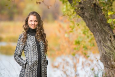 Sonbahar Nehri'nin bir arka plan üzerinde ağaç yakınındaki bir genç kız portresi