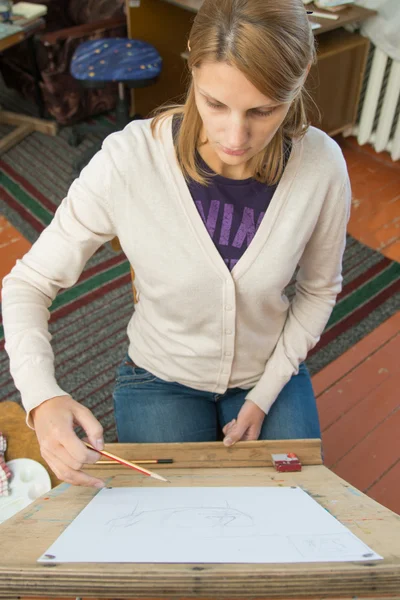 Een jong meisje schildert op een ezel in de studio van de kunstenaar — Stockfoto
