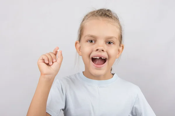 Meisje houdt de tand in zijn hand en zijn mond open tonen een gat tussen de tanden — Stockfoto