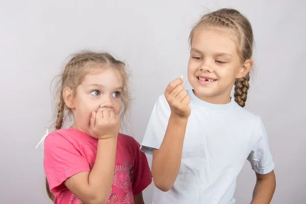 Chica de cuatro años con el miedo de mirar el diente perdido en su mano una niña de seis años — Foto de Stock