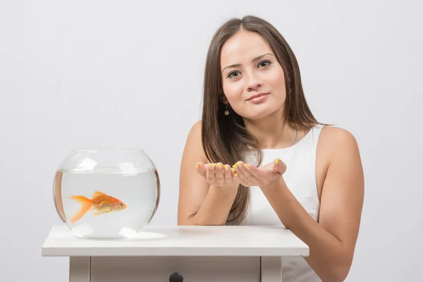 Zij vraagt om te voldoen aan de wens om een goudvis in een aquarium — Stockfoto