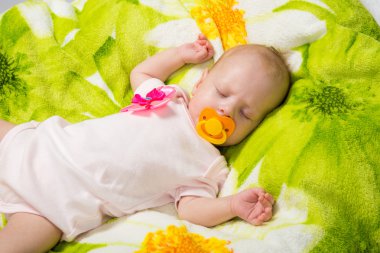 Sleeping two-month girl sucking a pacifier clipart