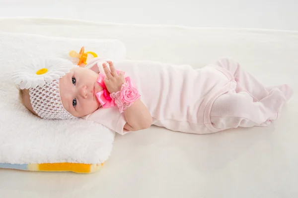 The two-month girl lying on the bed — Stock Fotó