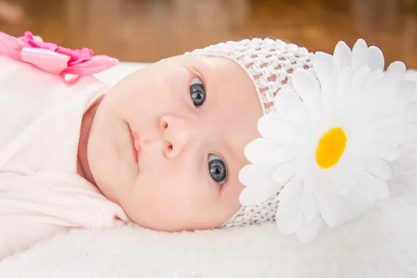 Portrait of a baby girl with a bandage on his head and a flower — Stock Photo, Image