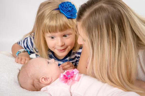 Five-year girl with amazement looks at his newborn sister — 图库照片