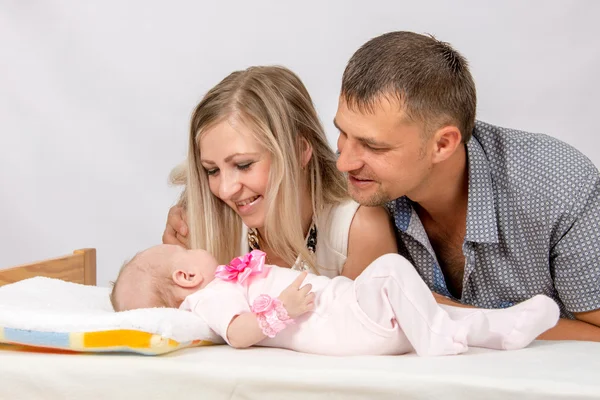 Happy Mom and Dad look at his two-month baby — ストック写真