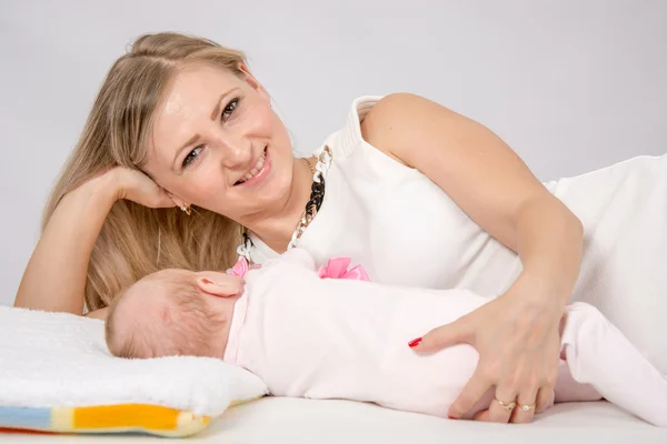 Mom hugged her baby lying next to him — Stockfoto