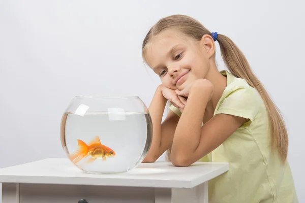 Zamyšlená dívka sní a při pohledu na zlaté rybky — Stock fotografie