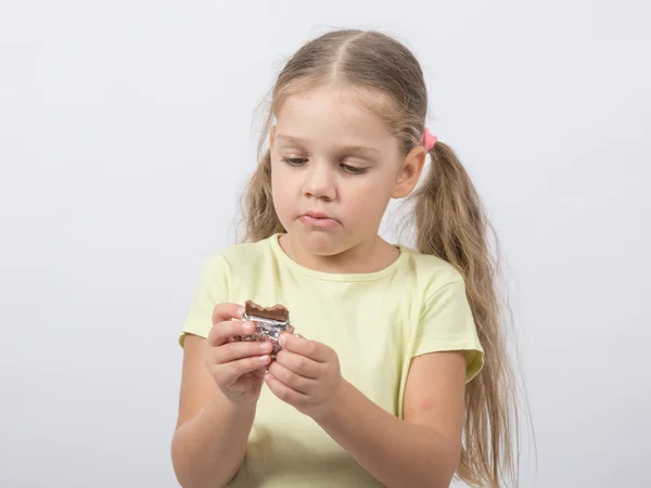 Four-year girl eats a chocolate sweet tooth — Stock Photo, Image