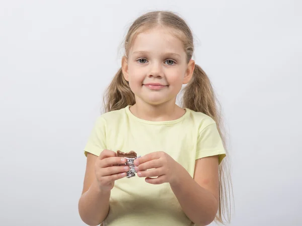 Retrato de um dente doce menina de quatro anos com chocolate na mão — Fotografia de Stock
