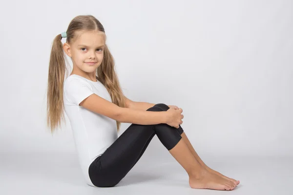 Gymnaste six ans assis étreignant ses genoux jambes — Photo