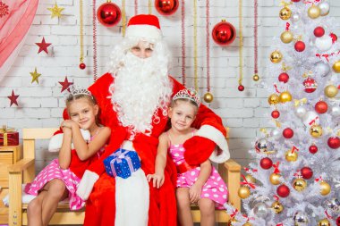 Santa Claus hugging two girls sisters