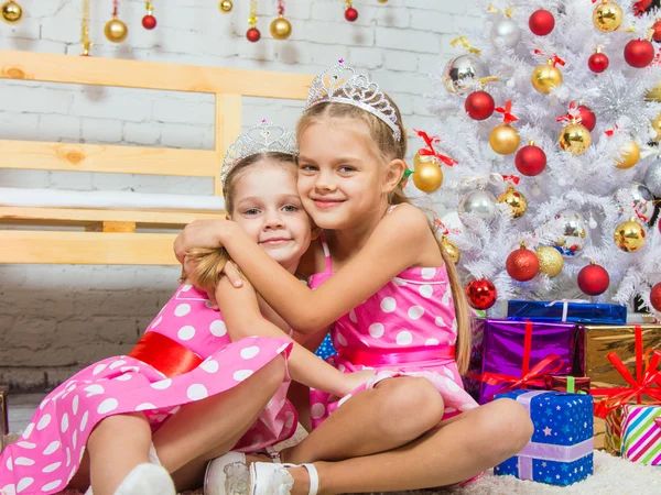 Two girls embrace at the Christmas trees — Stock Photo, Image