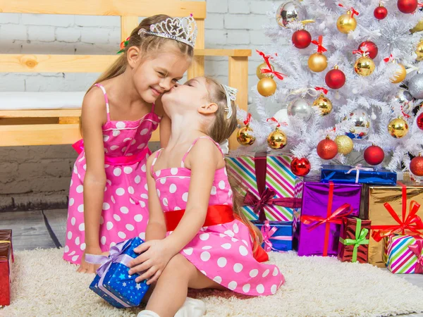 Girl kissing her sister because she gave her a gift — ストック写真