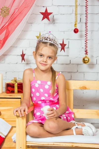 Menina sentada em um banco na decoração da sala de Natal — Fotografia de Stock