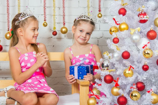 The girl gave her sister a Christmas gift — Stockfoto