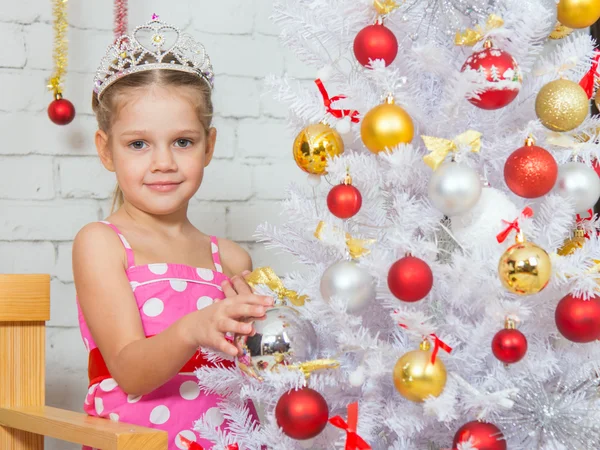 Girl hangs balls on a snowy New Years Christmas tree — ストック写真