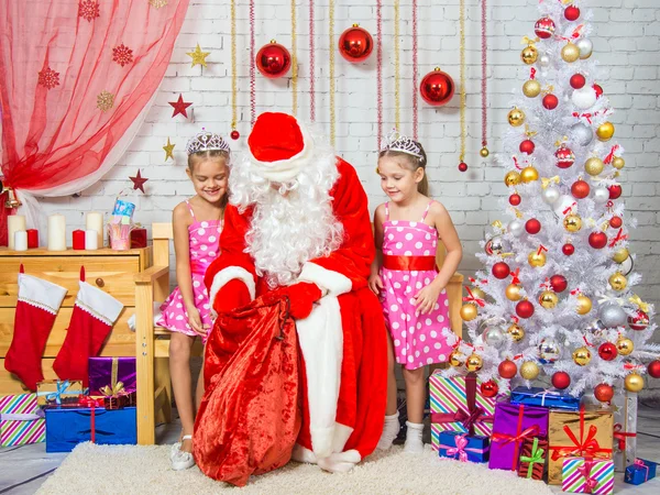 Babbo Natale tira fuori una borsa di regali a due ragazze — Foto Stock