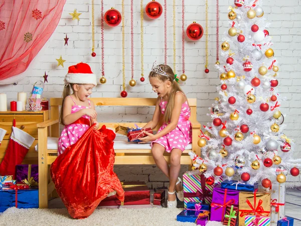 Dos chicas sacaron una bolsa de regalos de Navidad Santa Claus — Foto de Stock