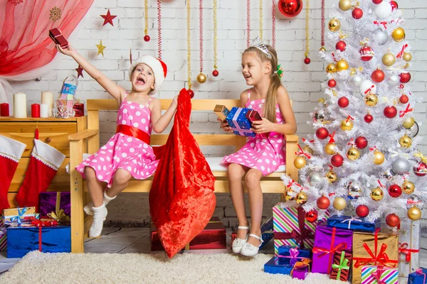 Две девушки веселятся и с Новым годом подарки из сумки Санта-Клауса — стоковое фото