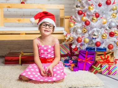Kız kırmızı şapka ve bir Noel ortamda halı komik yuvarlak gözlükleri