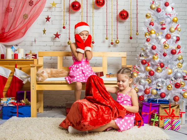 Девушка в кепке и варежках Санта-Клауса видела, как эта сумка забирается на другую девушку — стоковое фото