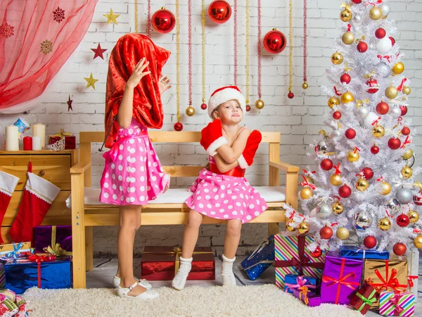 Chica con el bolso de Santa Claus en la cabeza, la otra chica se ofendió sentado en el banco — Foto de Stock