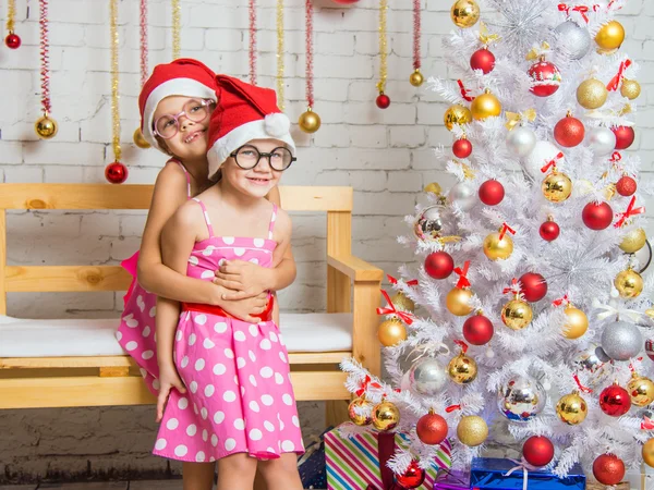 The girl hugged her sister back in the New Years home decor — Stock Photo, Image