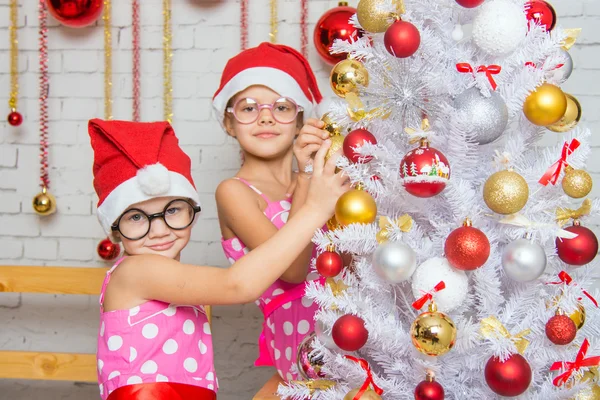 Dos chicas divertidas colgando bolas en el árbol de Navidad — Foto de Stock