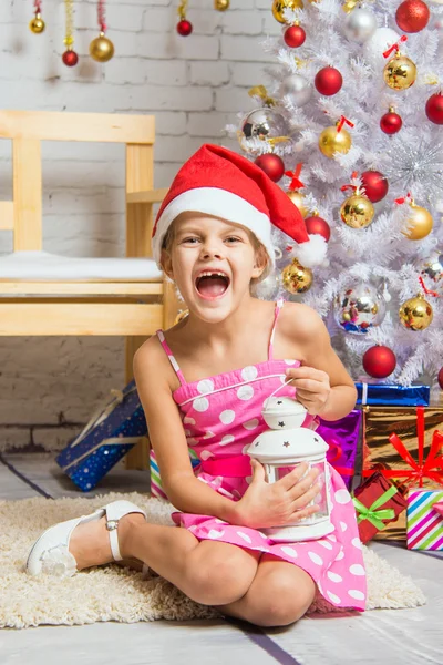 Fille crie heureux tenant bougie dans ses mains et assis près des arbres de Noël — Photo