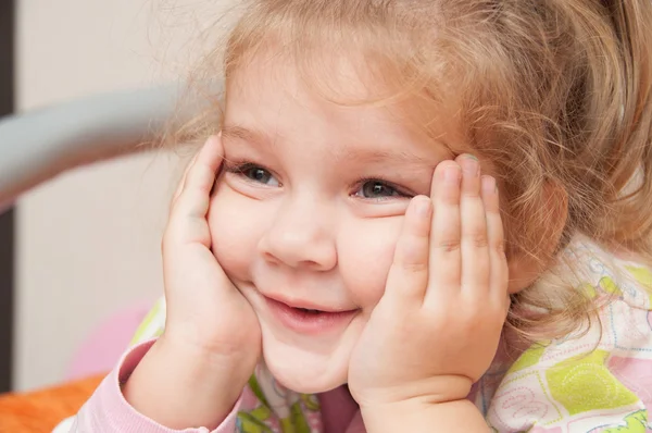 Tři roky dívka zájem, při pohledu na levé ruce oporou tváře — Stock fotografie