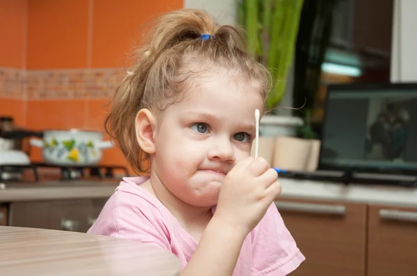 Girl with a funny looking angrily at a cotton swab — Stock Photo, Image