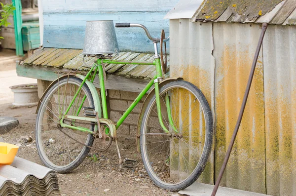 Bicicleta vieja con un cubo en la silla — Foto de Stock