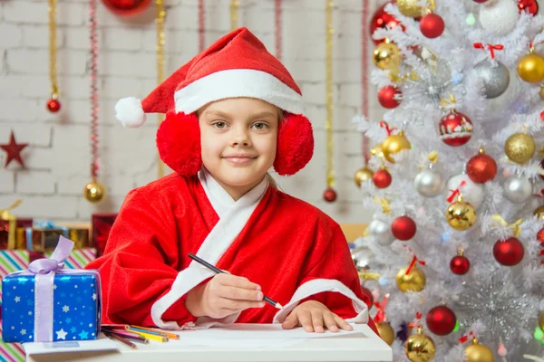Girl dressed as Santa Claus prepares New Years greetings — Stock fotografie