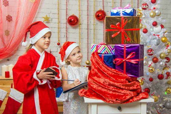 Santa Claus helper and collate a list of gifts — Stockfoto