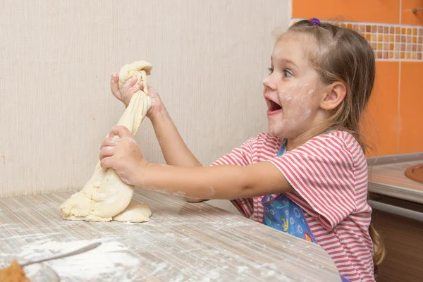 Cheerful girl tears off a piece of dough — Stock Photo, Image