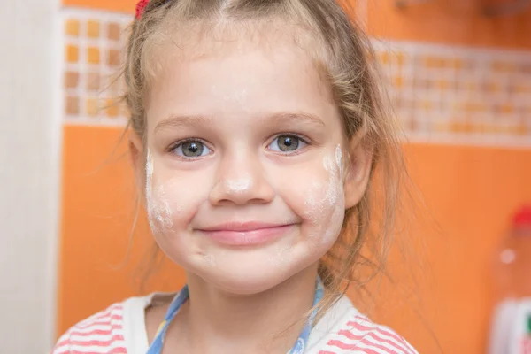 Portrait of a cheerful girl with a face stained with flour — Stock Photo, Image