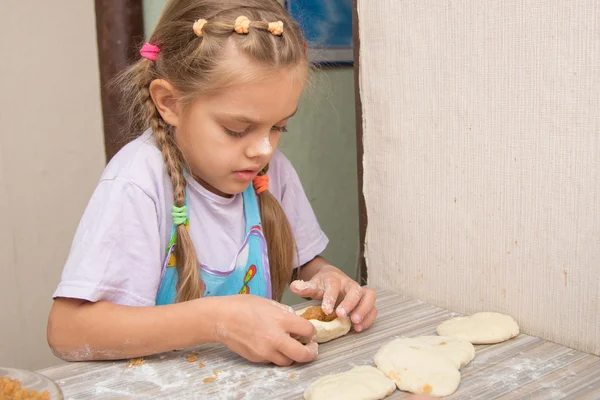 Menina de seis anos de idade concentrando esculpe bolos com repolho — Fotografia de Stock