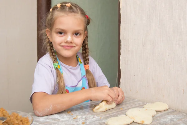 Menina alegre esculpe bolos com repolho — Fotografia de Stock