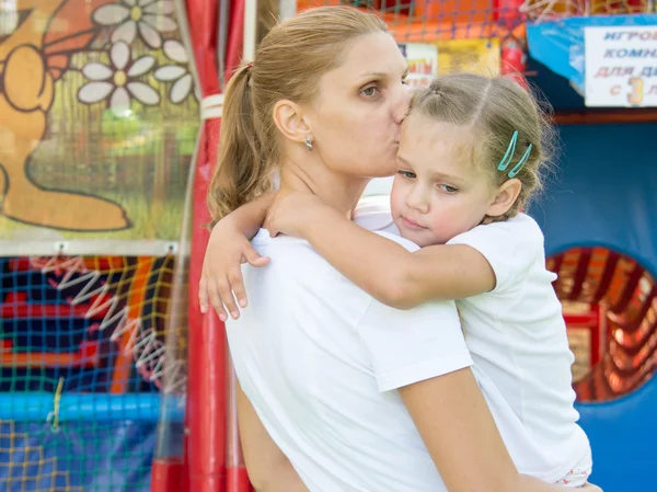 Junge Mutter Umarmungen und Küsse müde dreijährige Tochter hatte ein weiches Spielzimmer — Stockfoto