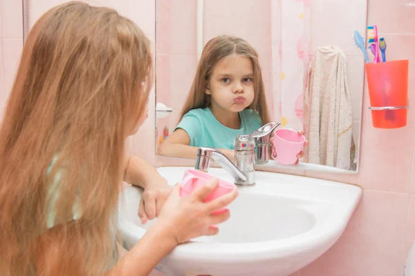 Chica enjuague su boca en el baño y mirar en el marco — Foto de Stock