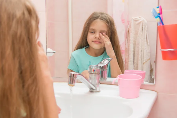 Девушка мокрая рука стирает сон из его глаз в ванной комнате — стоковое фото