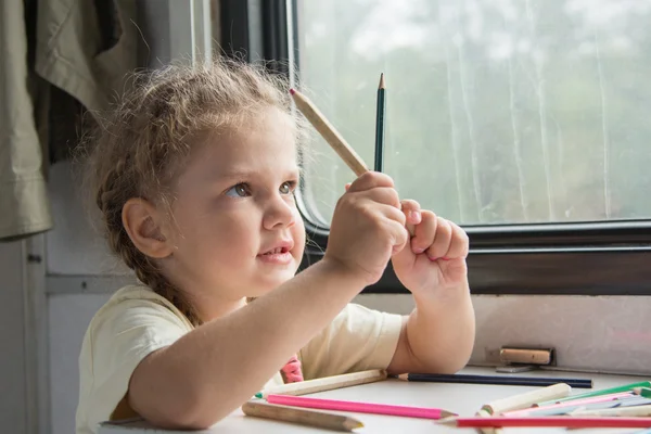 Fille a l'air drôle sur les crayons à la table dans le wagon de deuxième classe — Photo