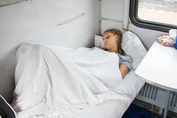 Tired young girl sleeping on a train — ストック写真