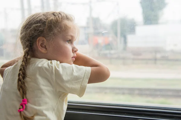 Girl with anxiety and sadness looks out the window of the train car — Stock Photo, Image