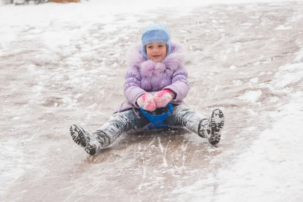 Five-year girl rolls on in the middle of the ice slides — Stock Photo, Image