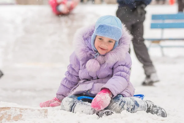 Joyful five years girl has slipped from the icy hill — Stock Photo, Image