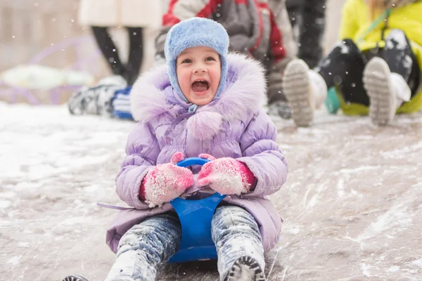 Cinq ans fille avec un cri heureux glissant glissements de glace — Photo