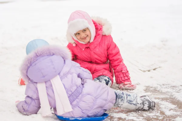 Two cheerful girls slid down the icy hill — Stock Photo, Image